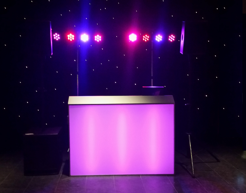 Een drive-in-show met LED-parren op een truss boven een dj-meubel