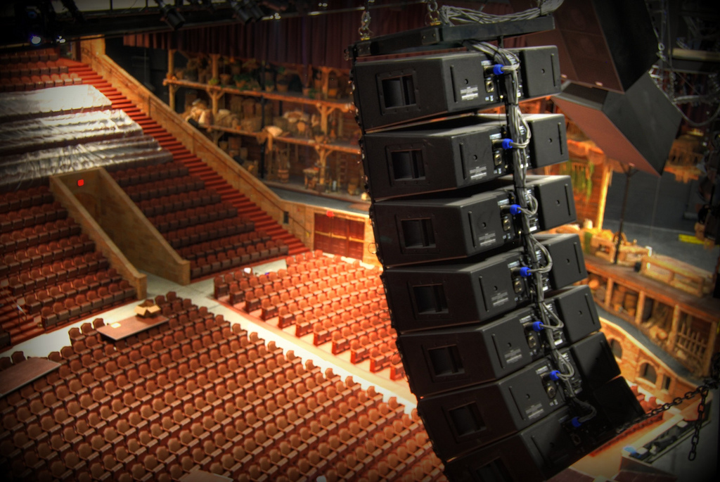 Een line array: meerdere luidsprekers boven elkaar opgehangen in een theaterzaal