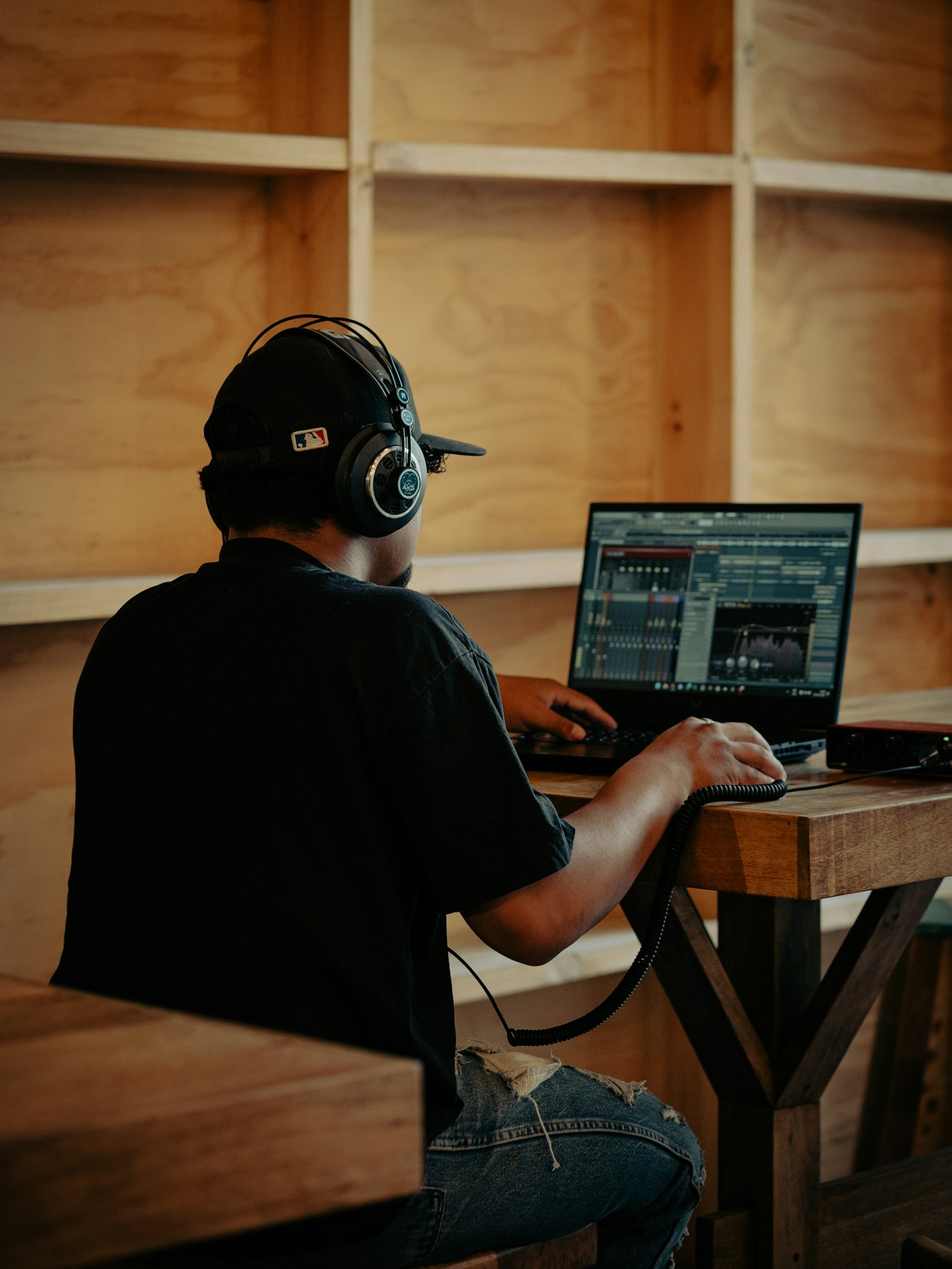 Een dj met koptelefoon achter een laptop